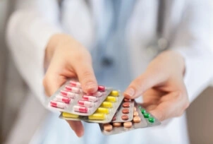 Lekarz trzyma w ręku różne leki i antybiotyki | Osłonka